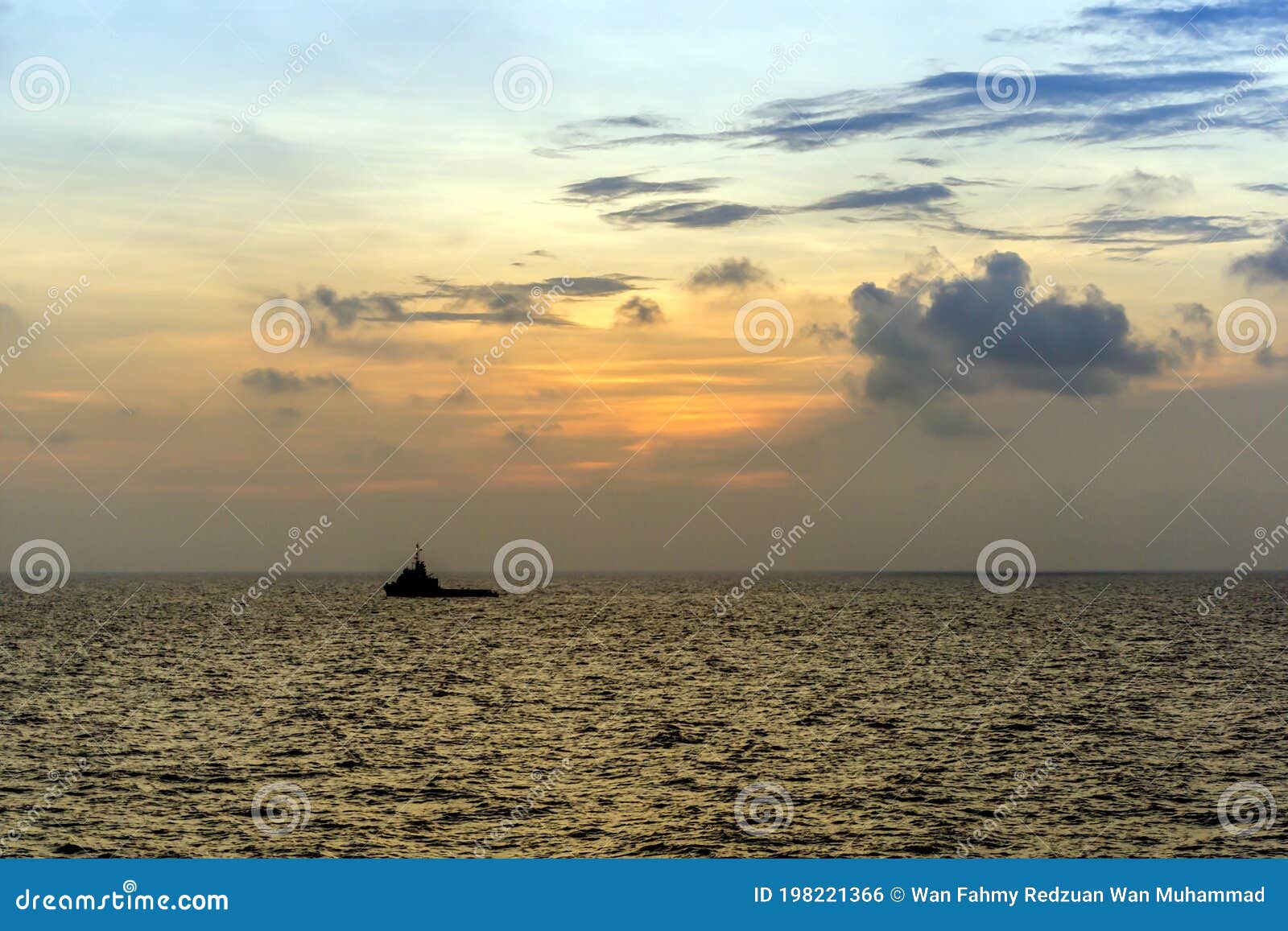 silhouette of an anchor handling tug boat at oil field during sunrise