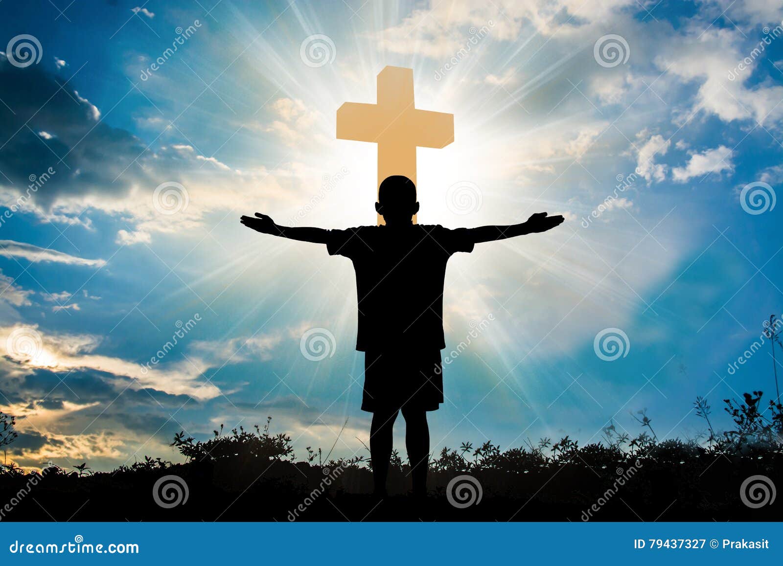 silhouette of boy praying to a cross with heavenly cloudscape sunset concept for religion, worship, love and spirituality