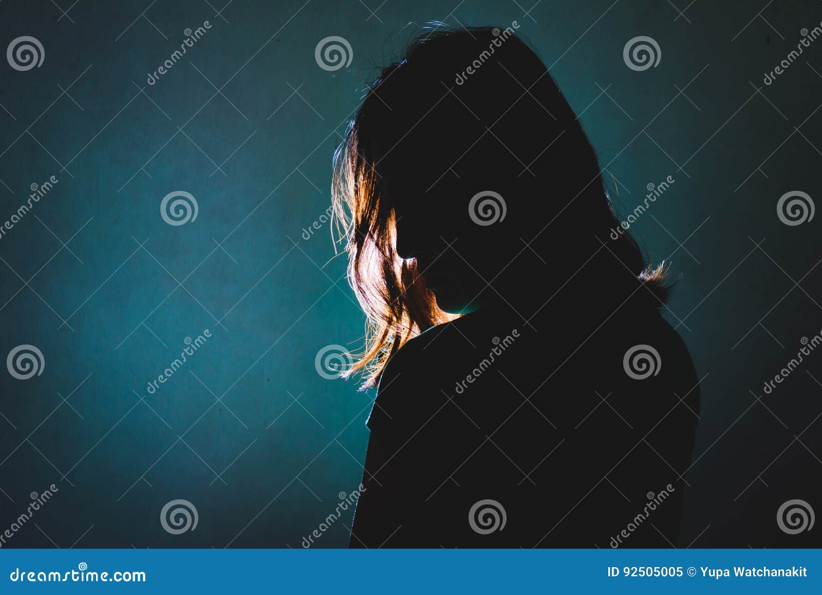 silhouette of depress woman standing in the dark with light shin