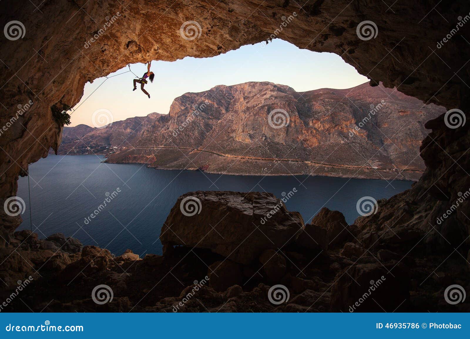 silhouette of female rock climber on cliff in cave