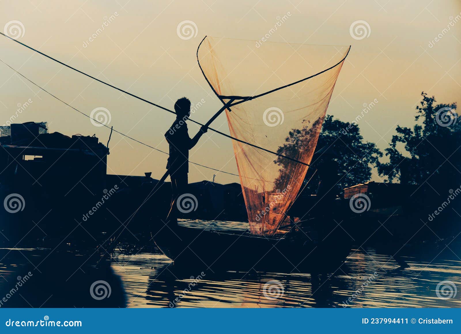 Silhouette of a Fisherman Casting a Fishing Net Stock Image