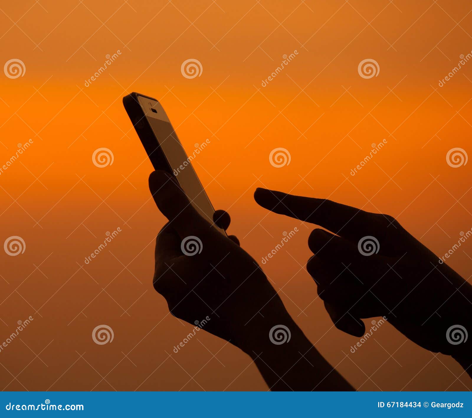 silhouette of hand using mobile device