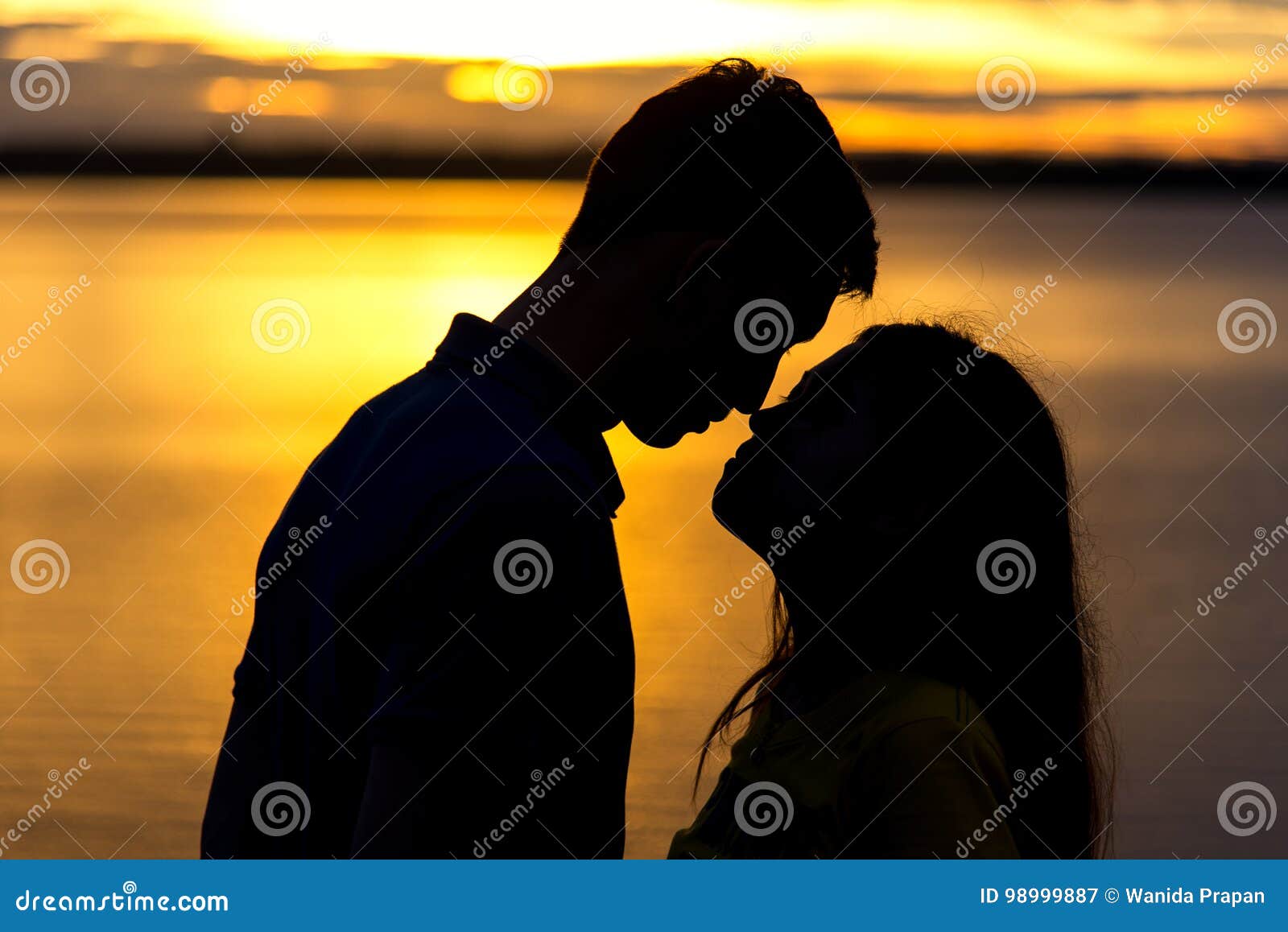 silhouette of happy couple in love kissing romantic at sunset.