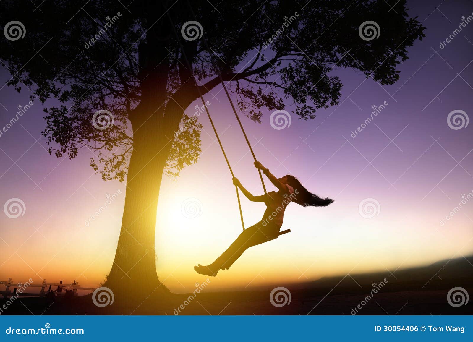 silhouette of happy young woman on swing