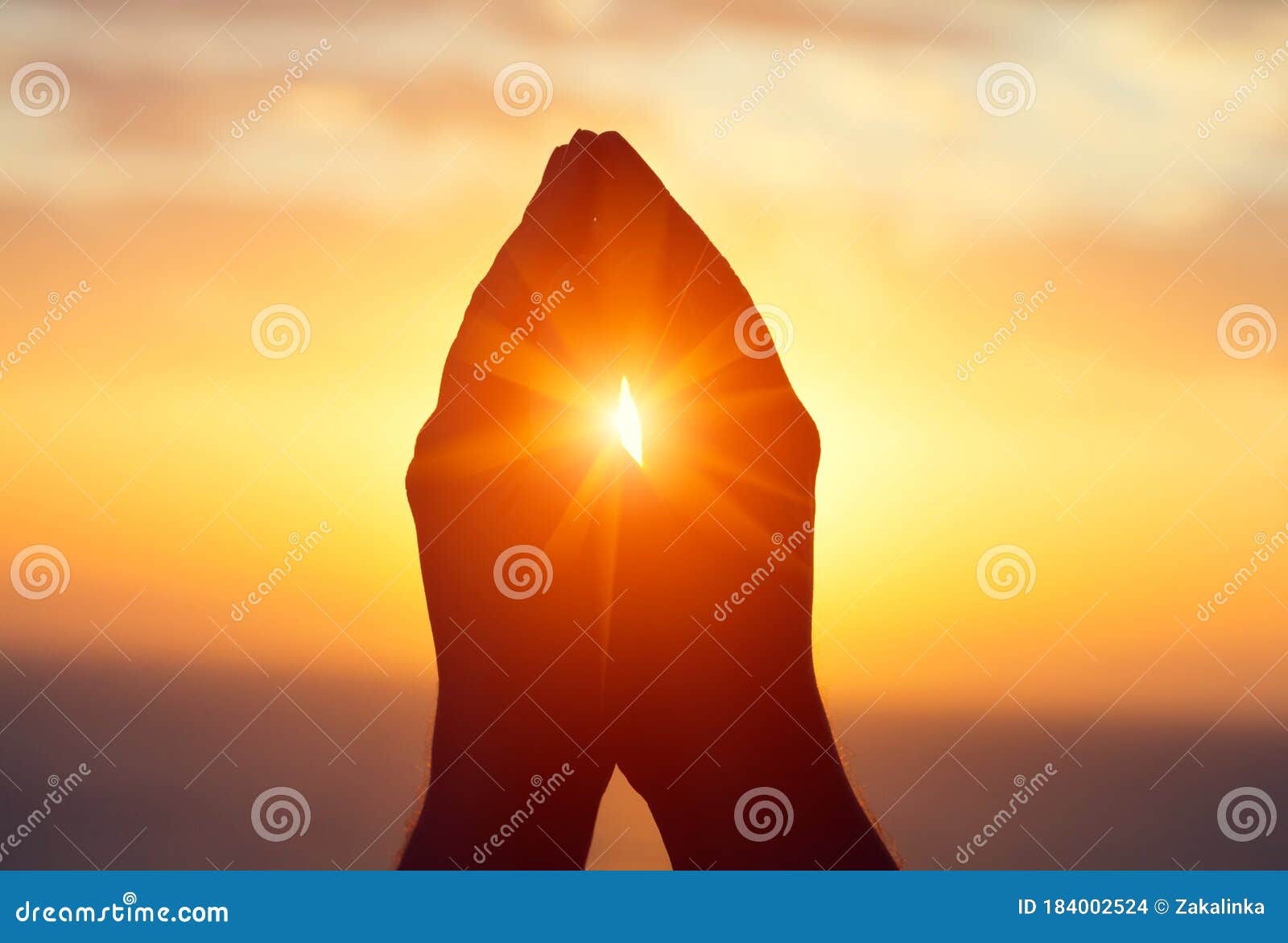 silhouette of male  raising hands praying for god`s blessings at sunset or sunrise light
