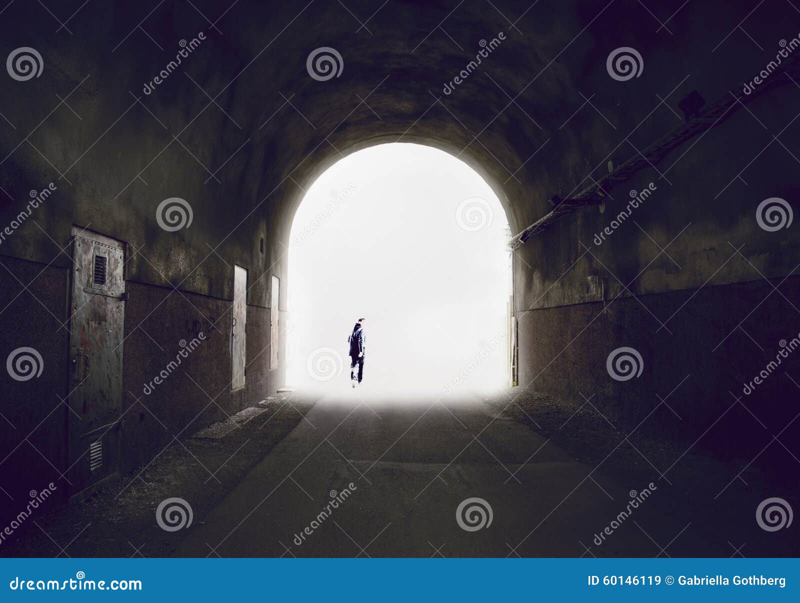 silhouette of a man disappearing into the light at the end of a tunnel.
