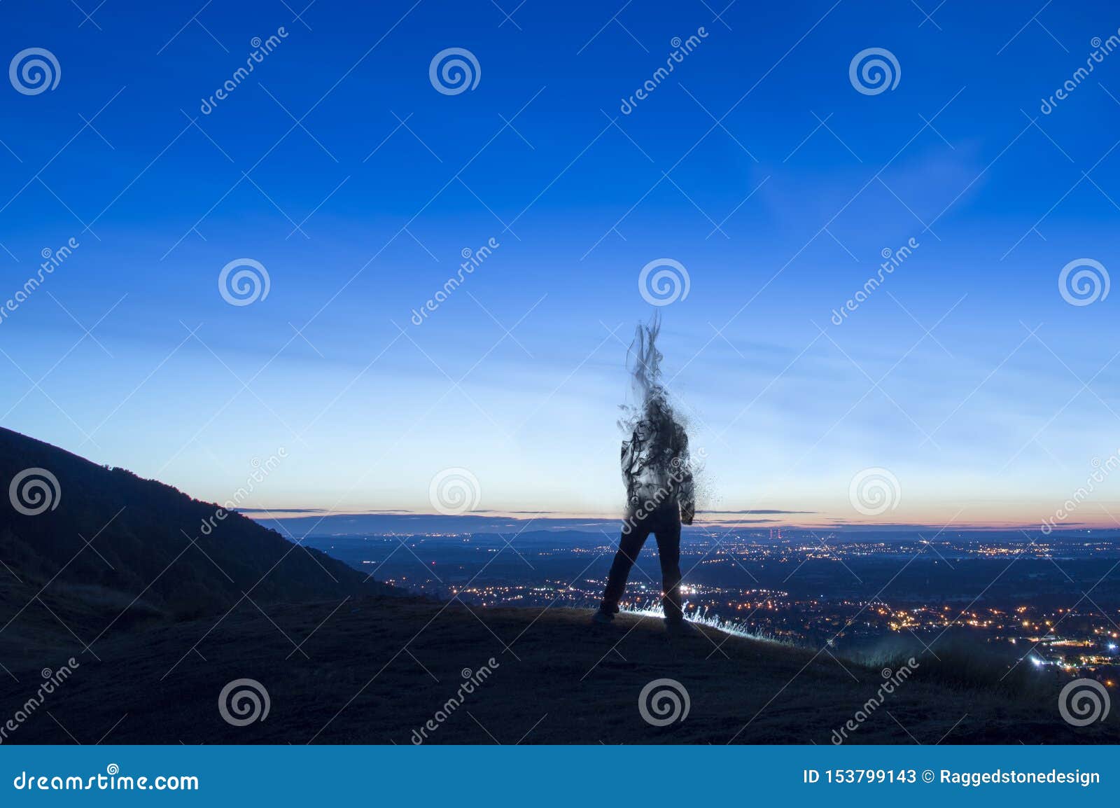 a silhouette of a man disappearing and turning into smoke. standing on a hill. lookng out on city lights just before sunrise