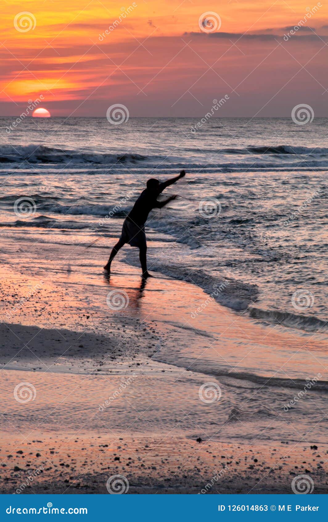 A Silhouette of a Man Throwing a Cast Net for Bait Fish with the