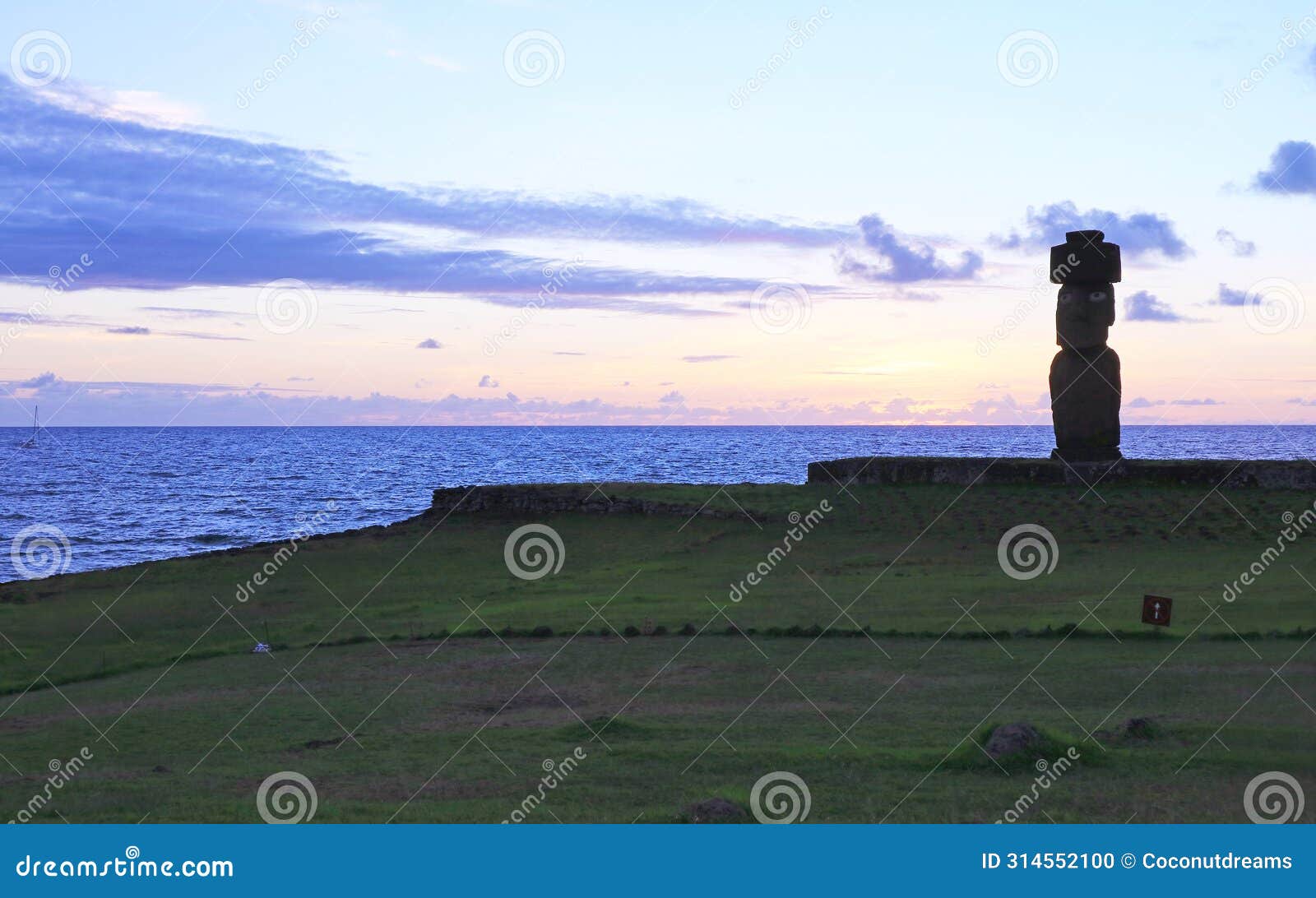 silhouette of moai with pukao hat of ahu ko te riku ceremonial platform, with pacific ocean in the backdrop, easter island