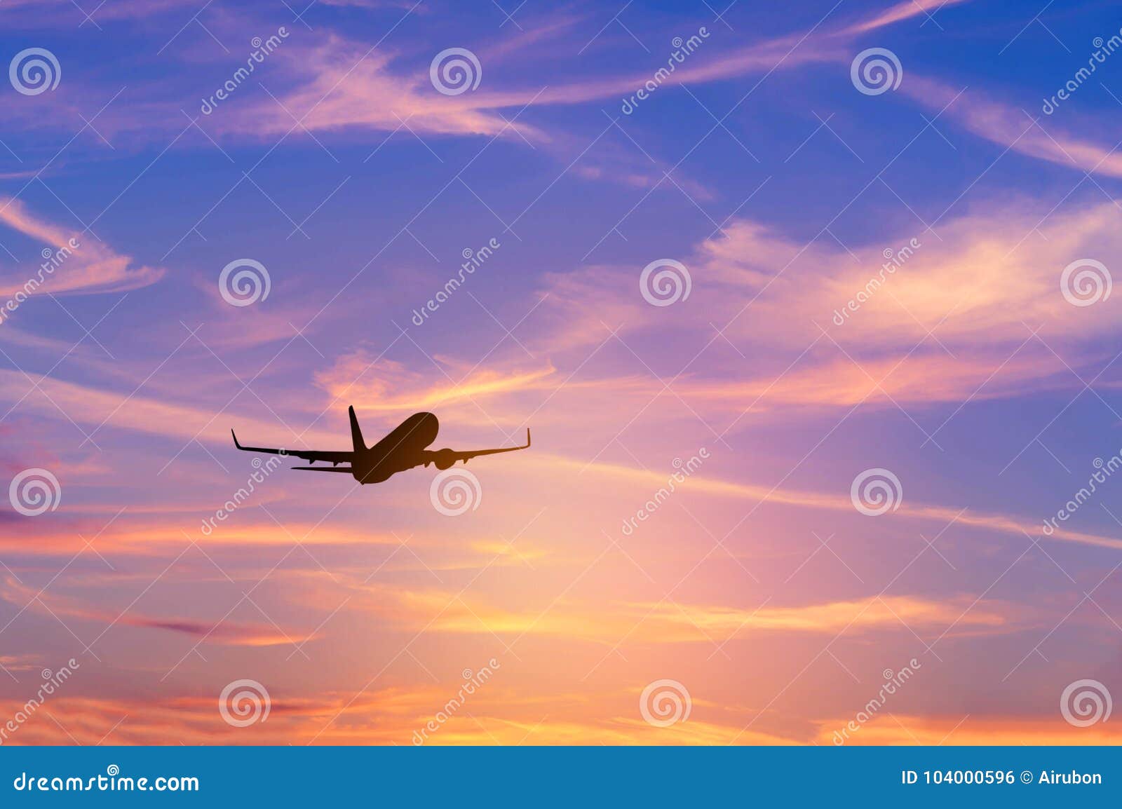 silhouette passenger airplane flying away in to sky high altitude during sunset time