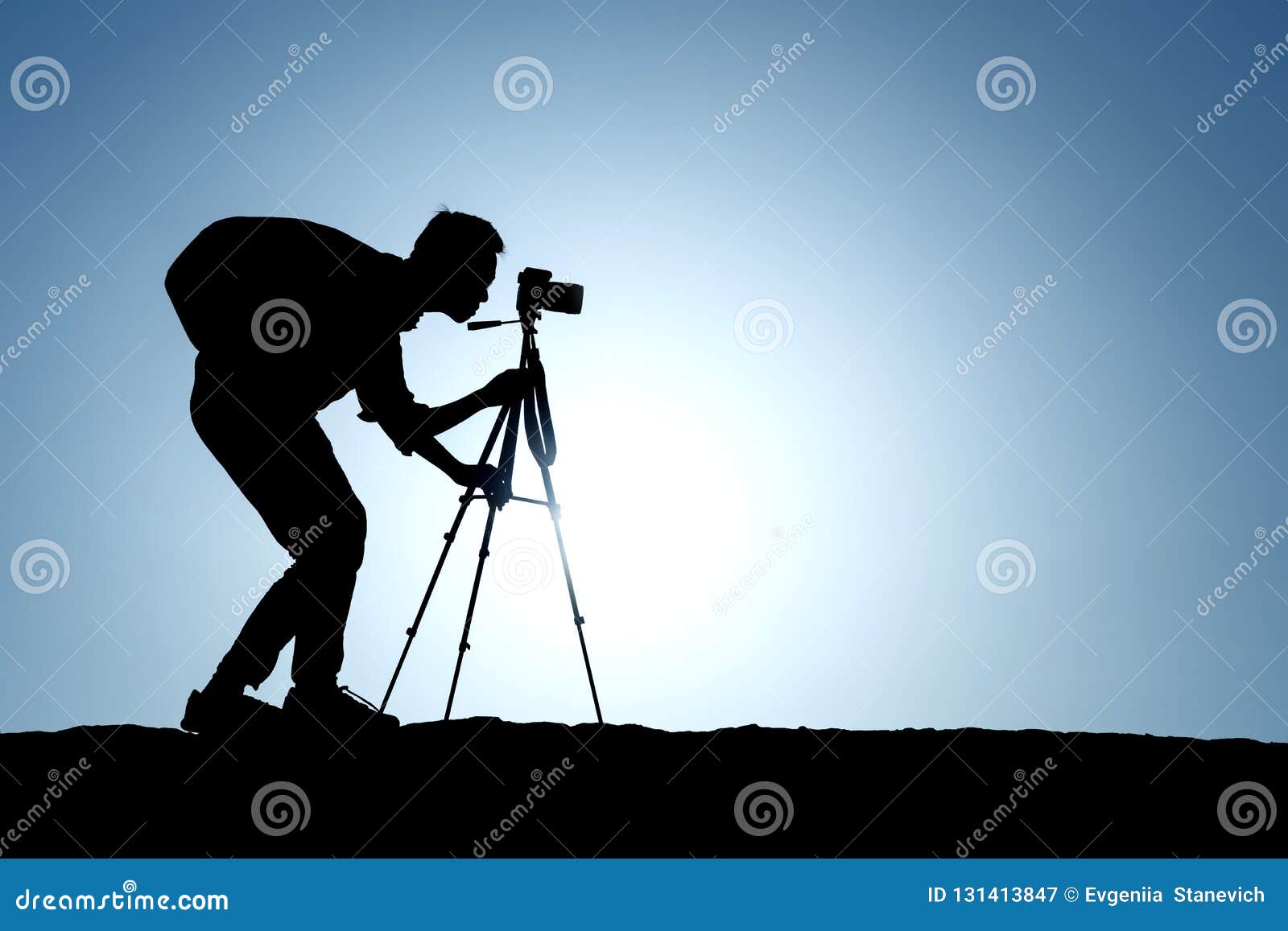 a silhouette of a photographer with a tripod