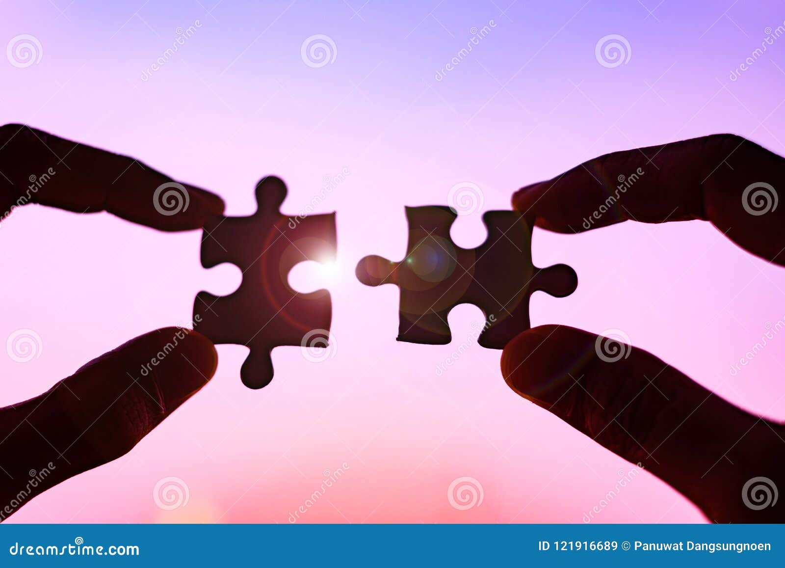 hands connecting couple puzzle piece against sunrise effec