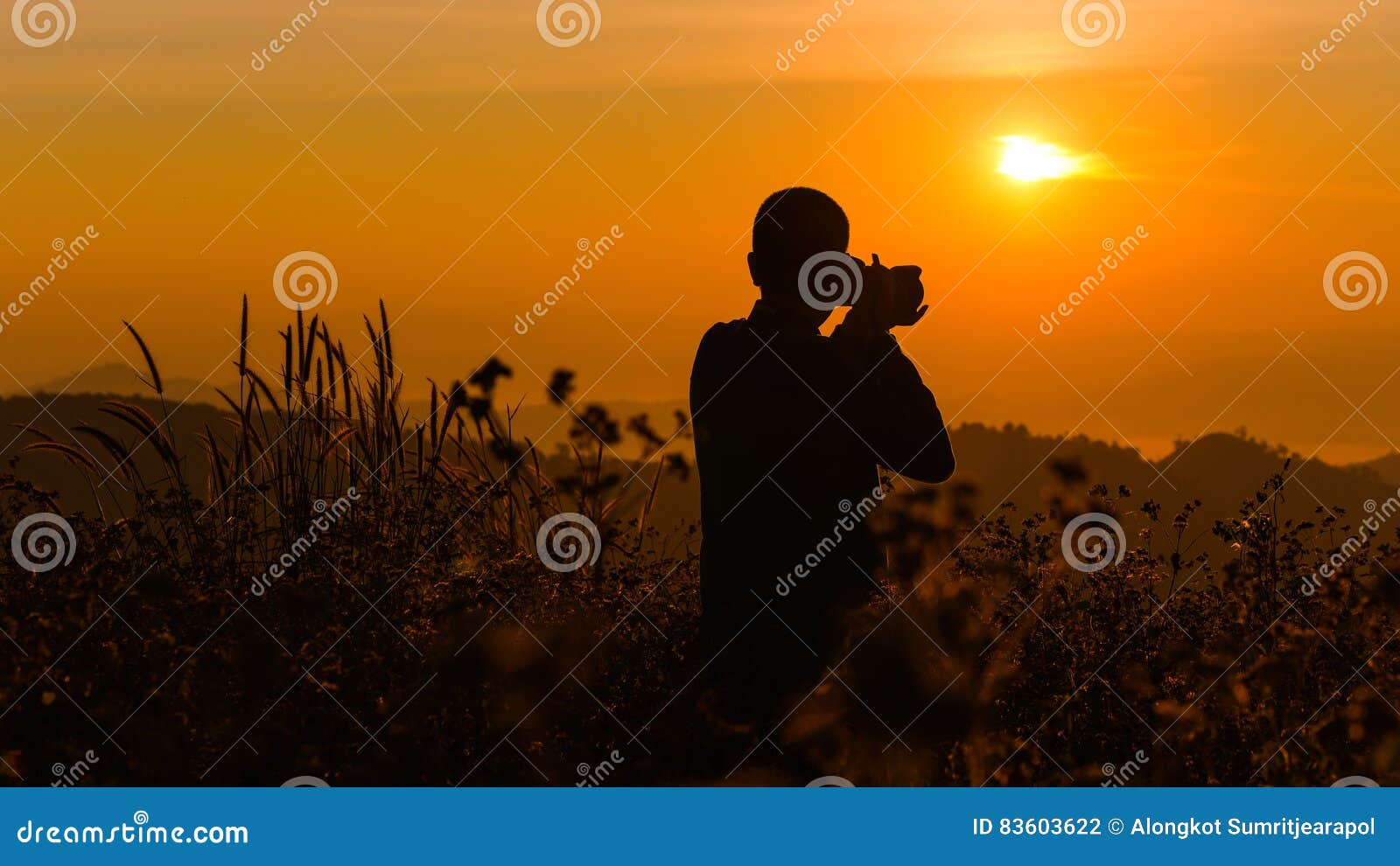 Silhouette of a young who like to travel and photographer, taking pictures of the beautiful moments during the sunset ,sunrise.