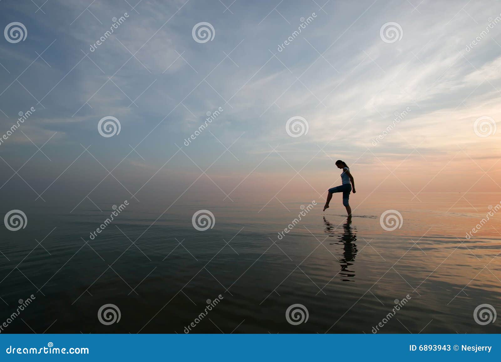 silhouette of young woman wading in sea