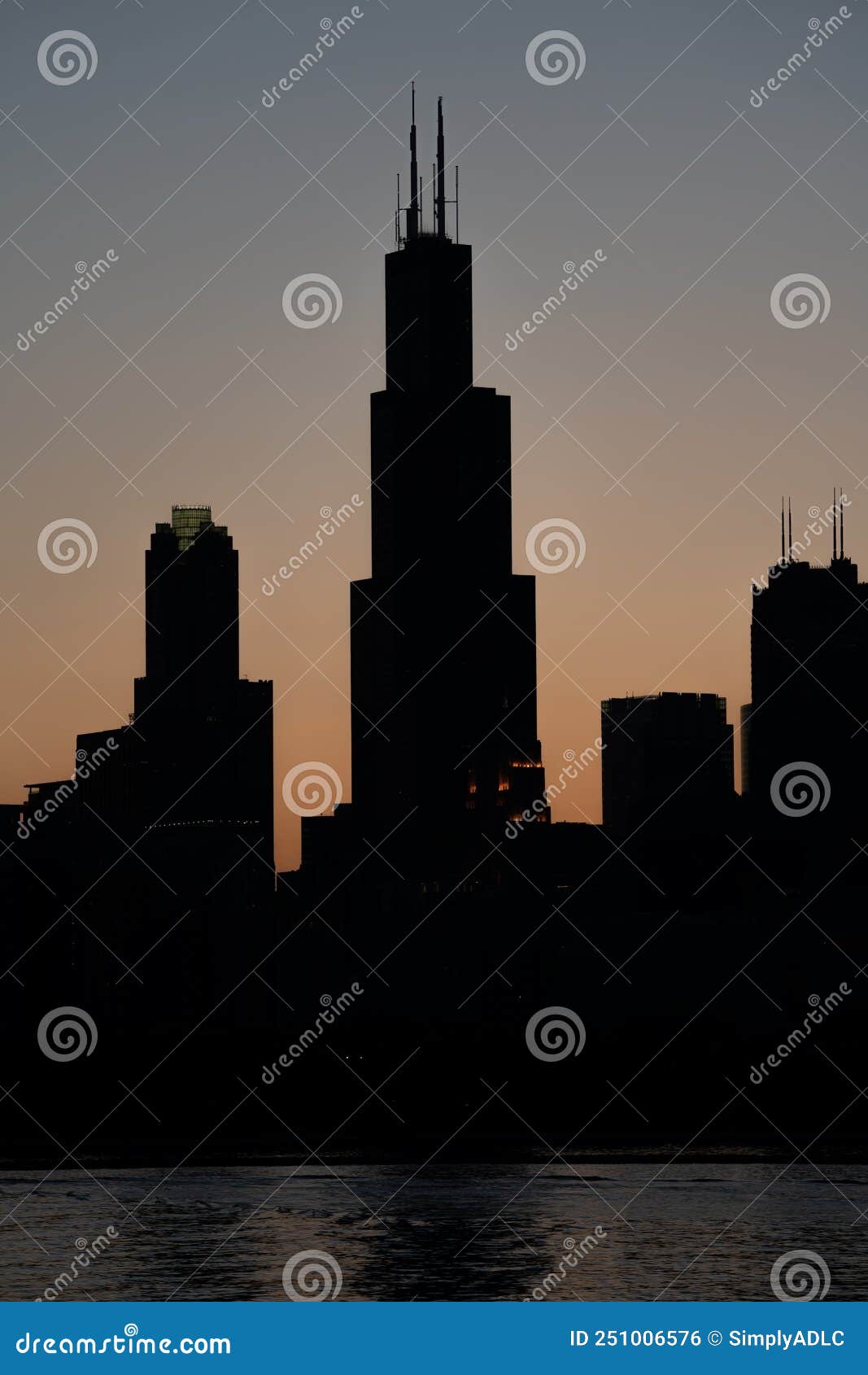 silhouettes of chicago highrises over the sunset sky