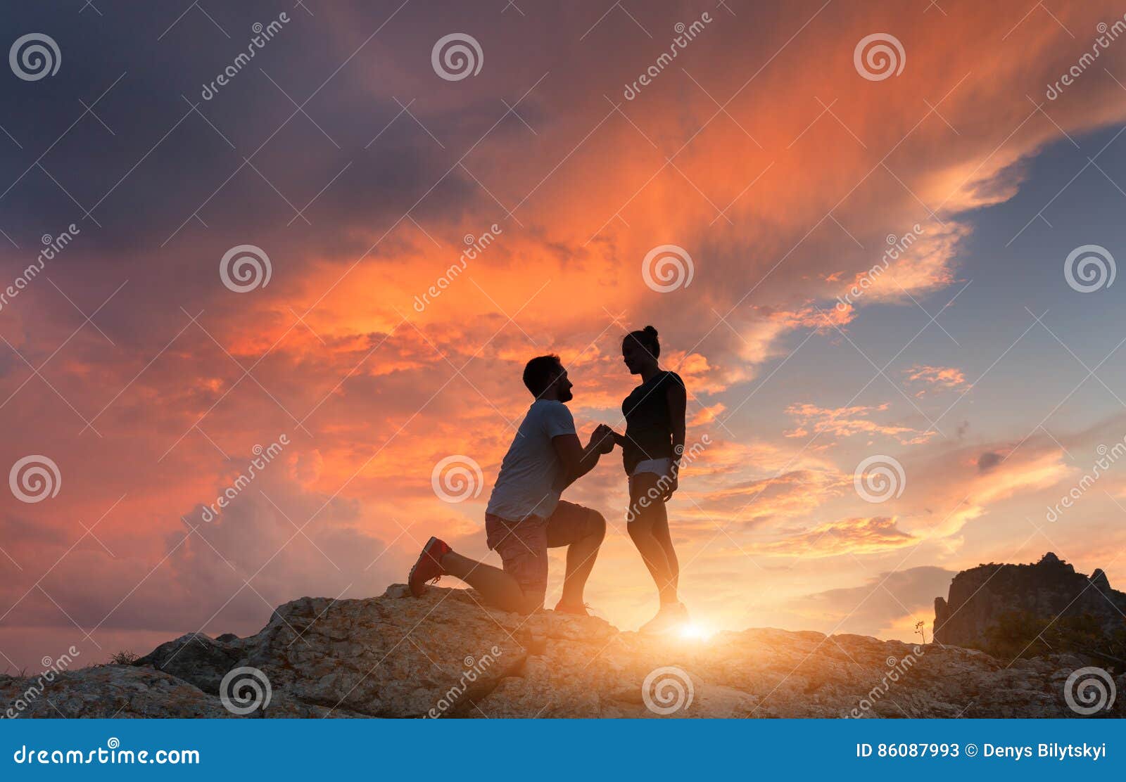 silhouettes of a man making marriage proposal to his girlfriend