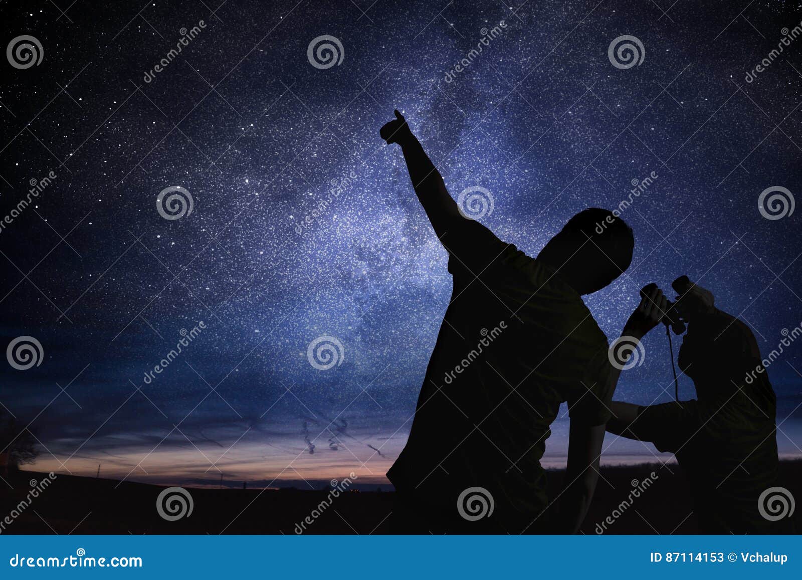 silhouettes of people observing stars in night sky. astronomy concept