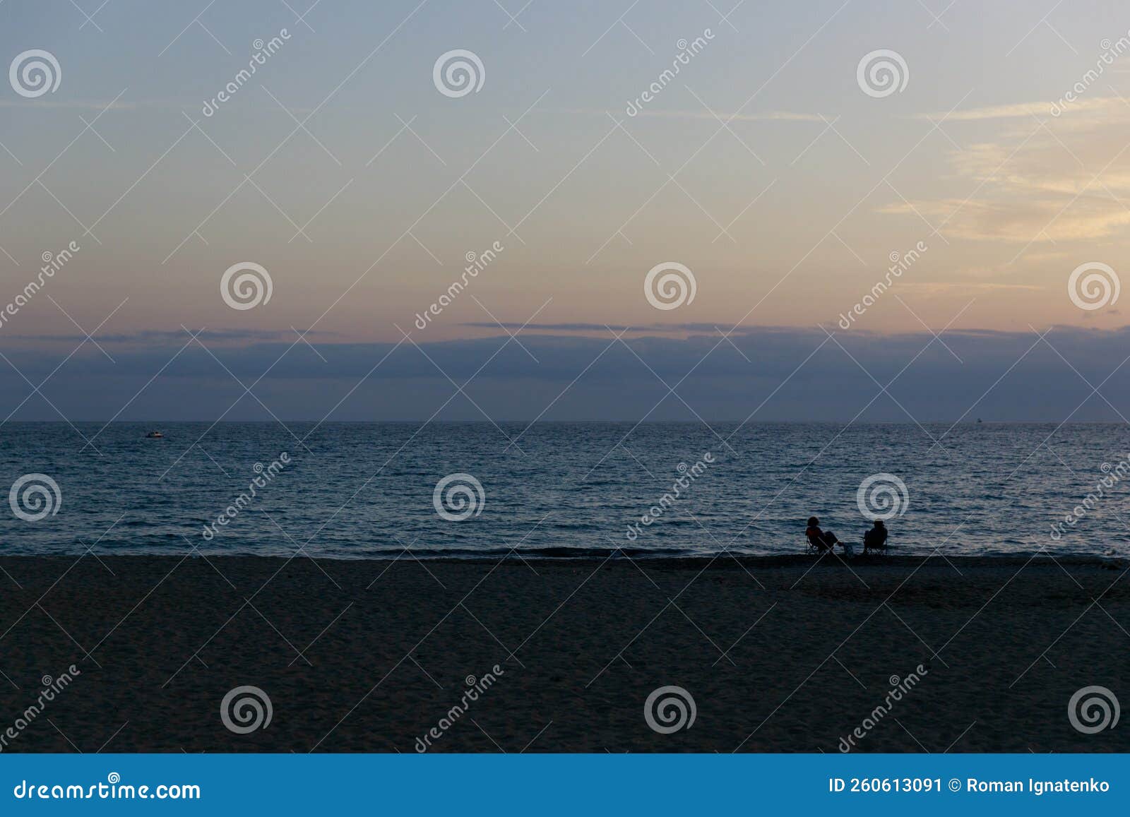 Silhouettes of Two People Sitting on the Beach at Sunset Stock Image ...