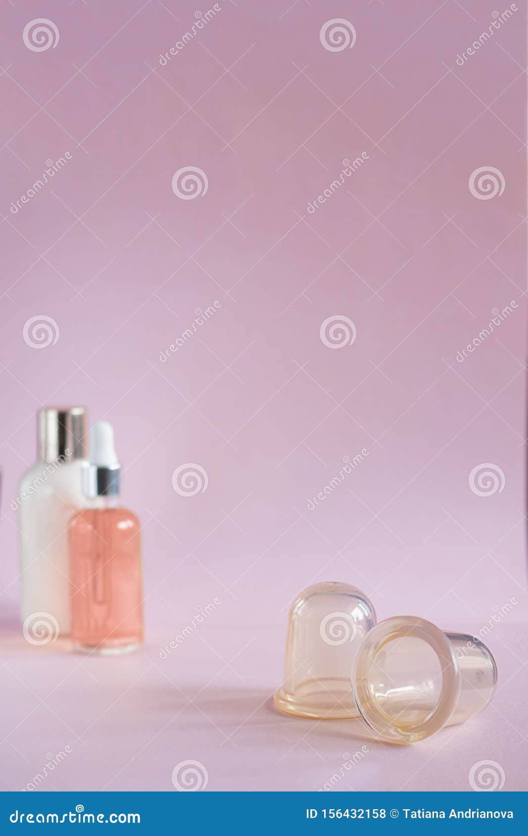 silicon vacuum cuppings and defocused mochup bottles, woman body and skincare things, items for cellulite, on pink empty