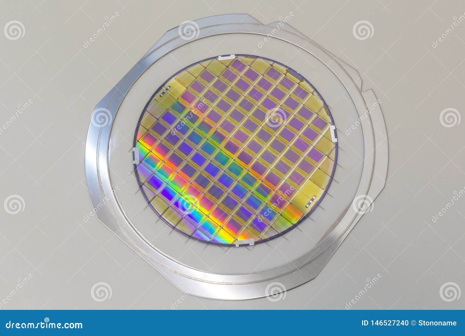 silicon wafer with microchips fixed in the holder with steel frame on the grey background and ready for process