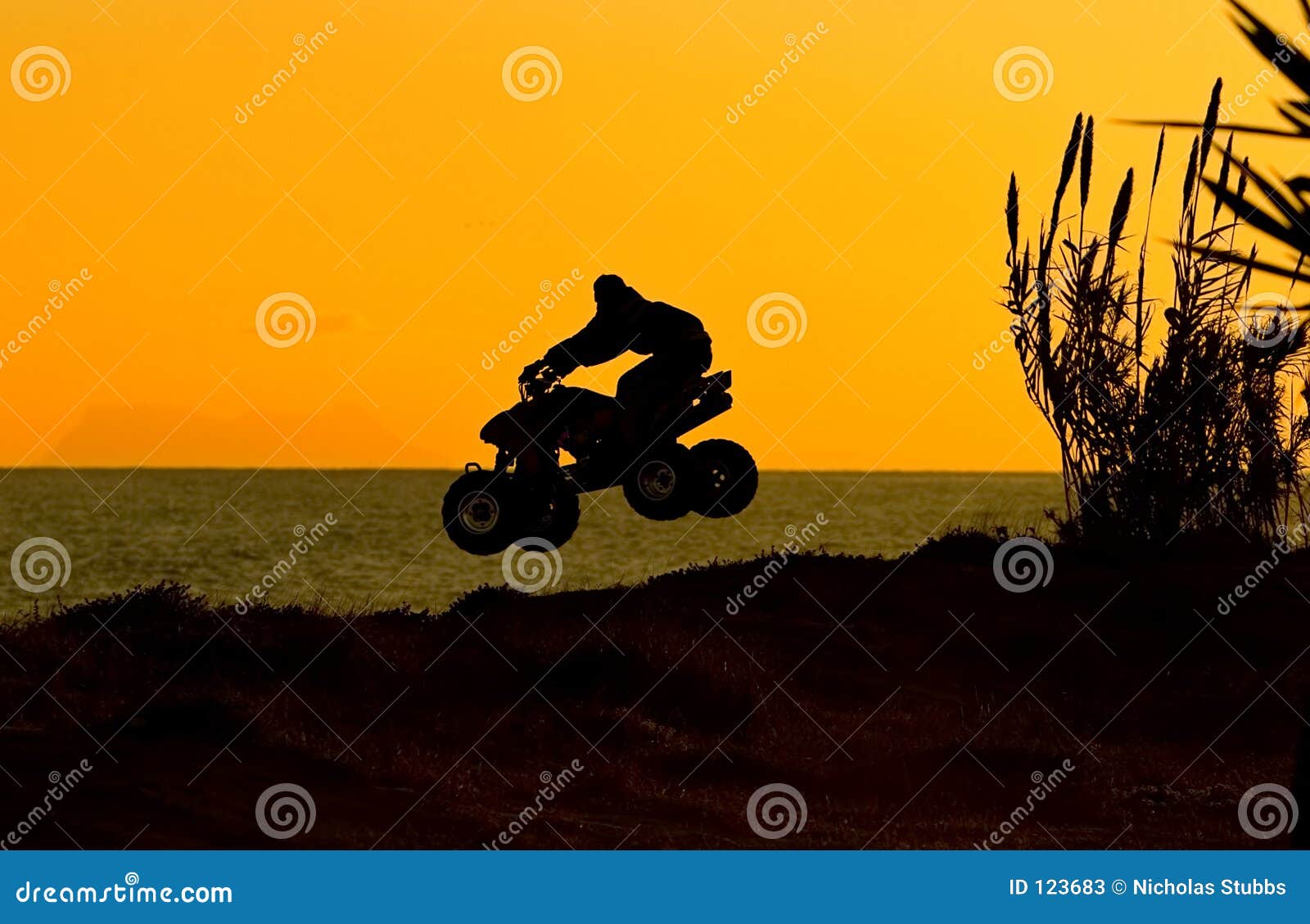 silouette of quad bike jumping