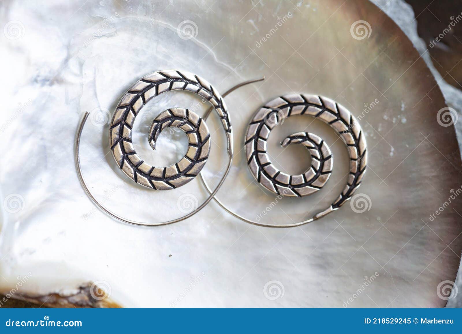 metal decorative oriental spirale  earrings on natural neutral background