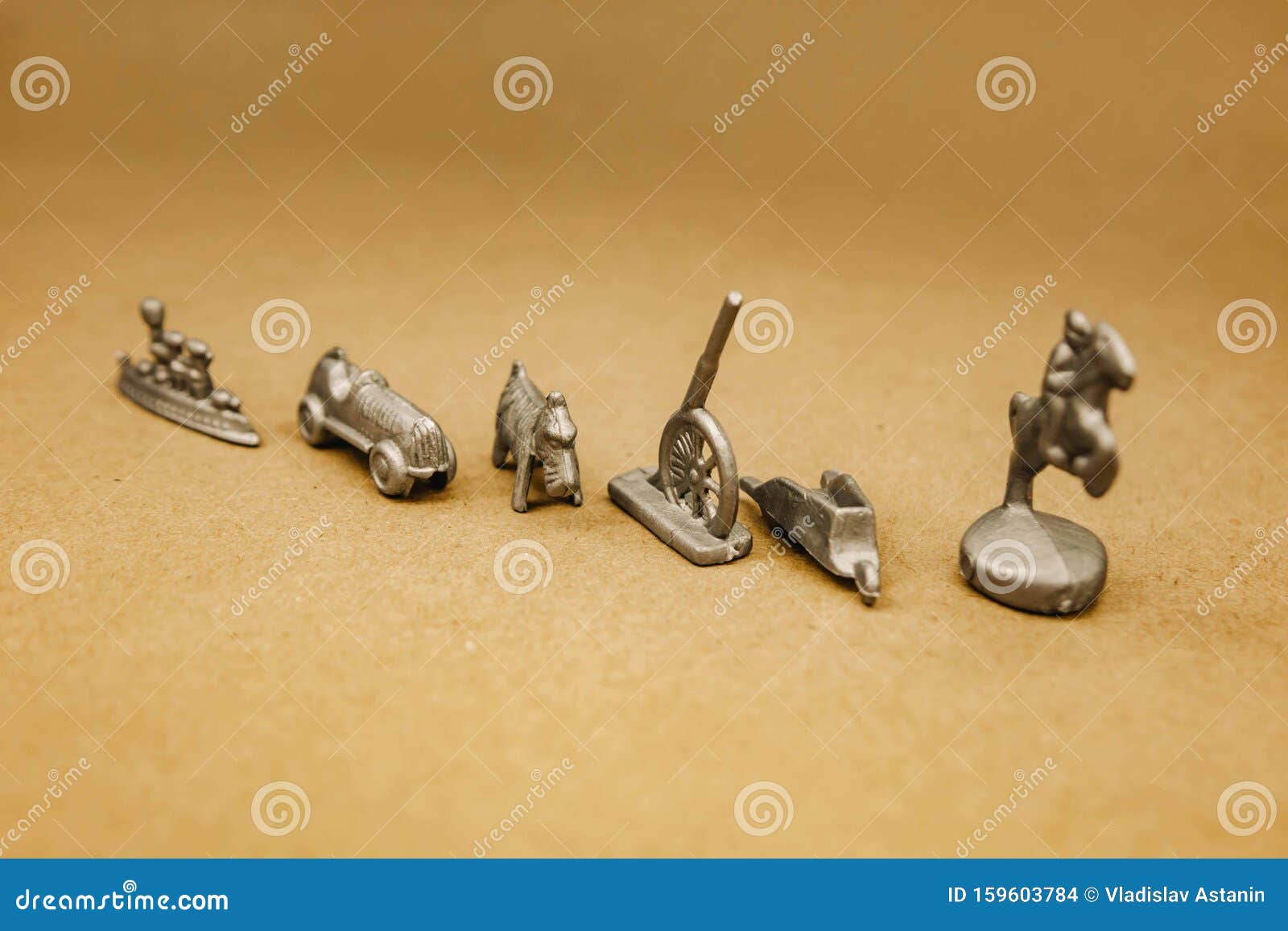 Silver Miniature Figurines Standing on a Gray Background Stock Photo