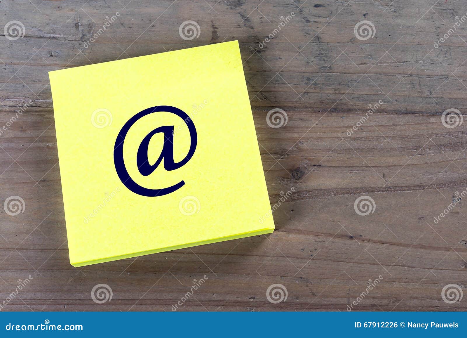 Simbolo del email sul Post-it. Post-it giallo con l'icona scritta del email su fondo di legno Copi lo spazio