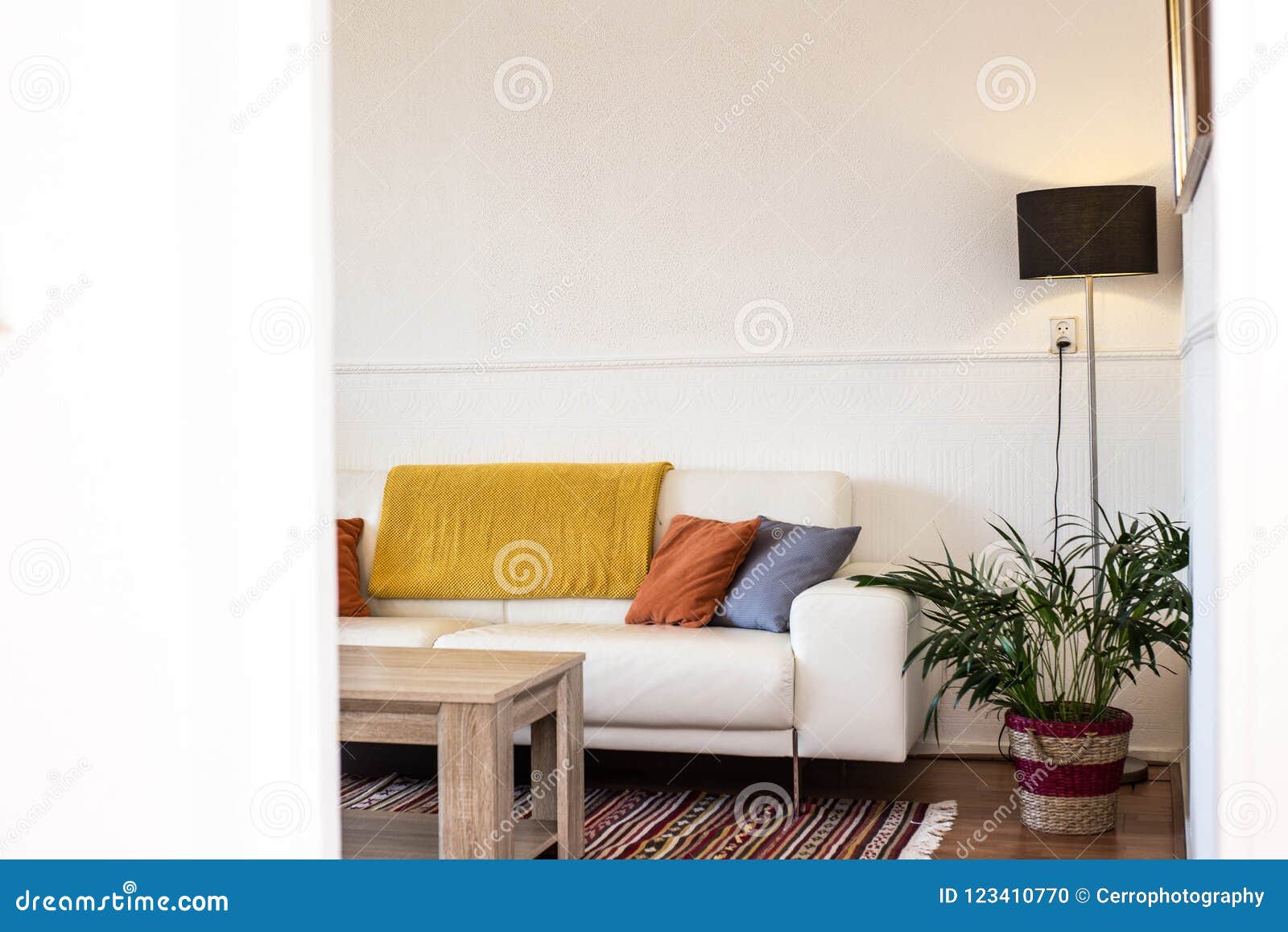 Simple Industrial Interior Design Of Living Room With Wooden Table Standing In Front Of A Gray Sofa With Yellow And Blue Cushions Stock Photo Image Of Floor Couch 123410770