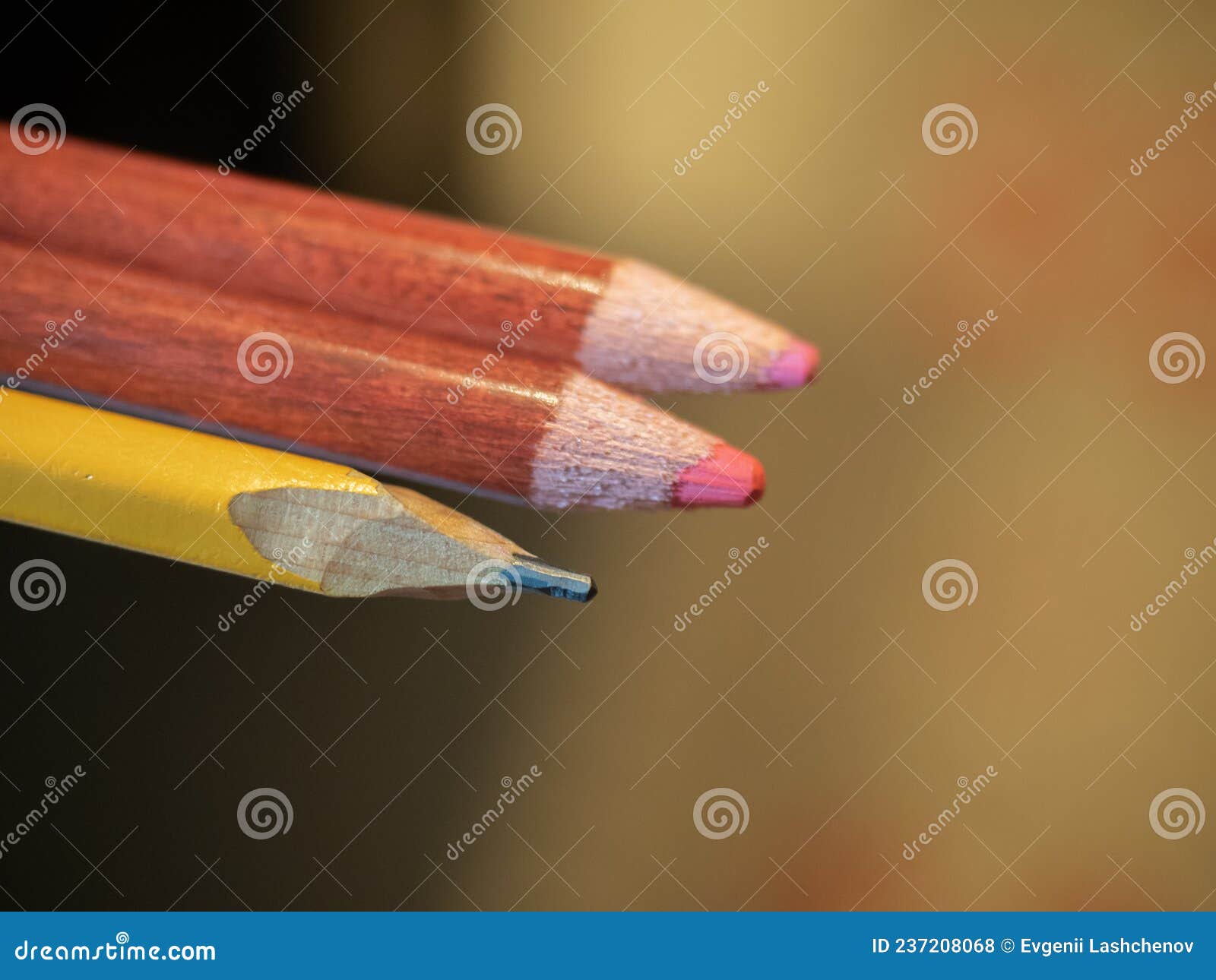 A Simple Pencil and Two Colored Ones on a Blurry Background Stock Photo