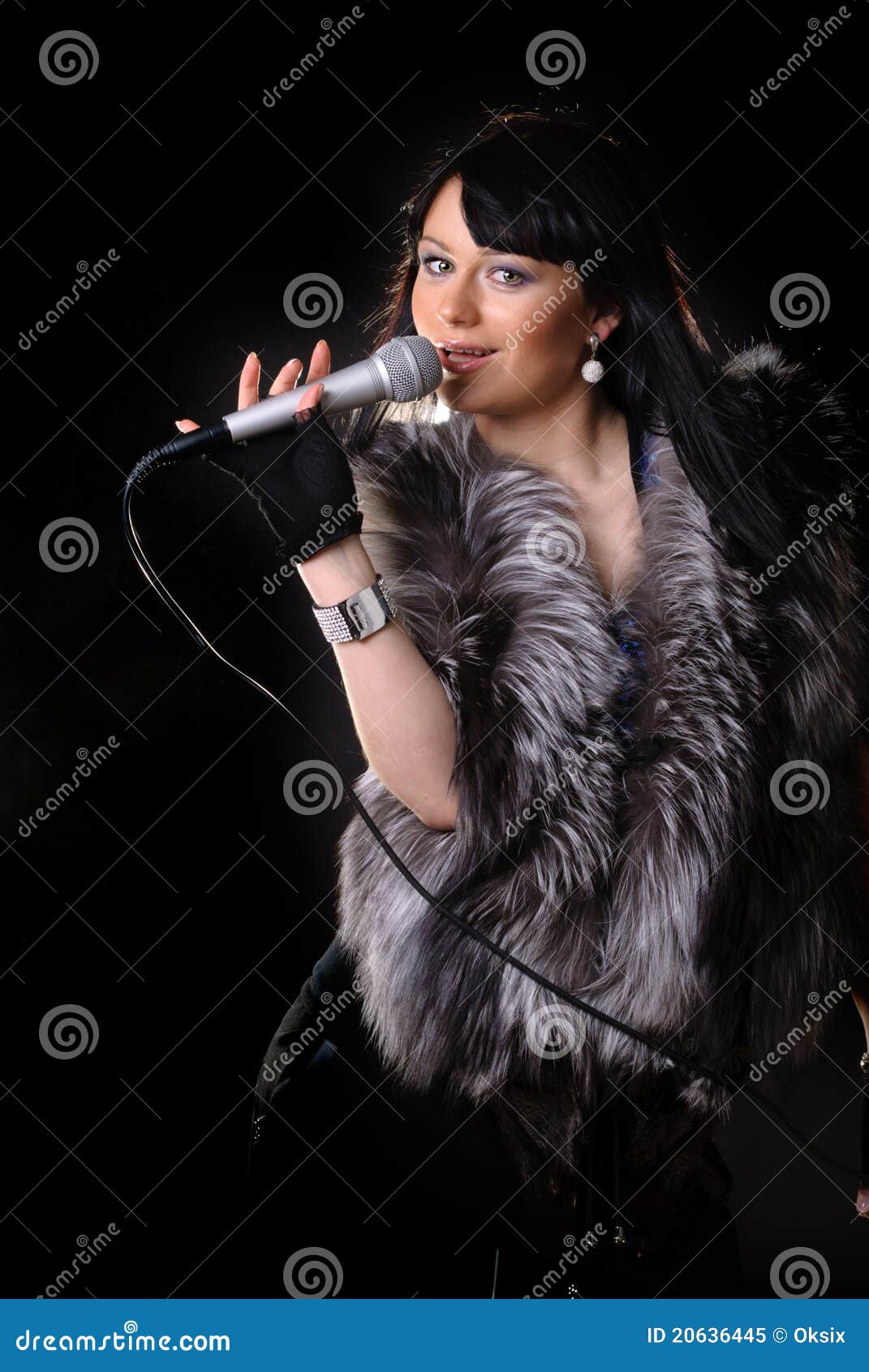 Singer on black. Woman singer in fur coat on black backgound