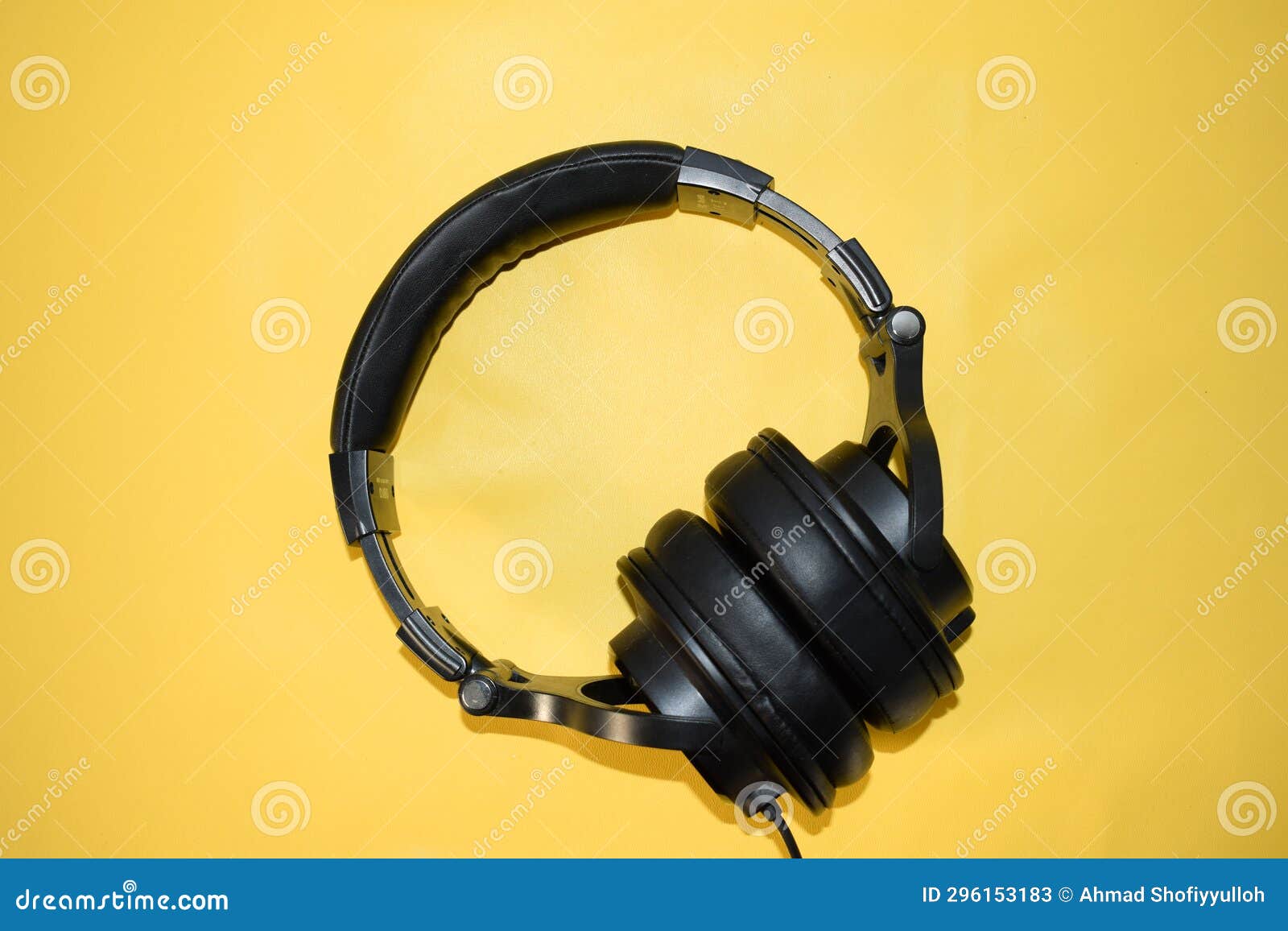 A Single Black Headphone with Cable Isolated Background Stock Image