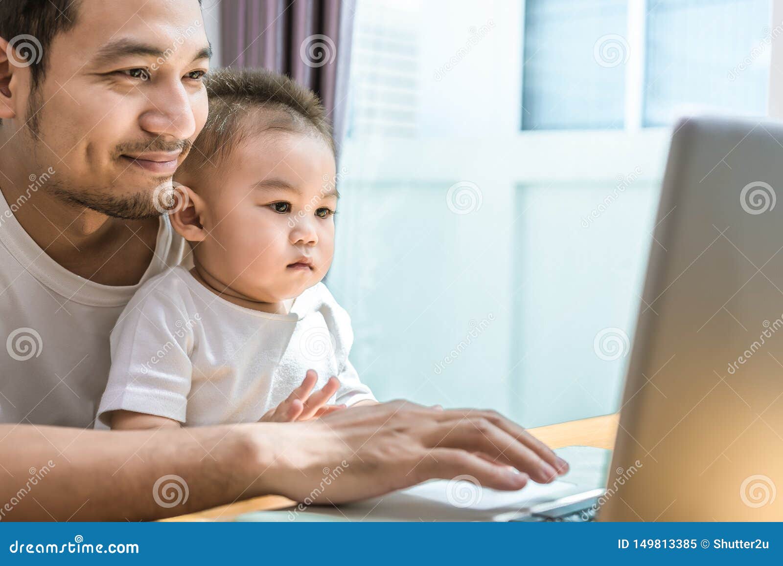 single dad and son using laptop together happily. technology and lifestyles concept. happy familly and baby theme