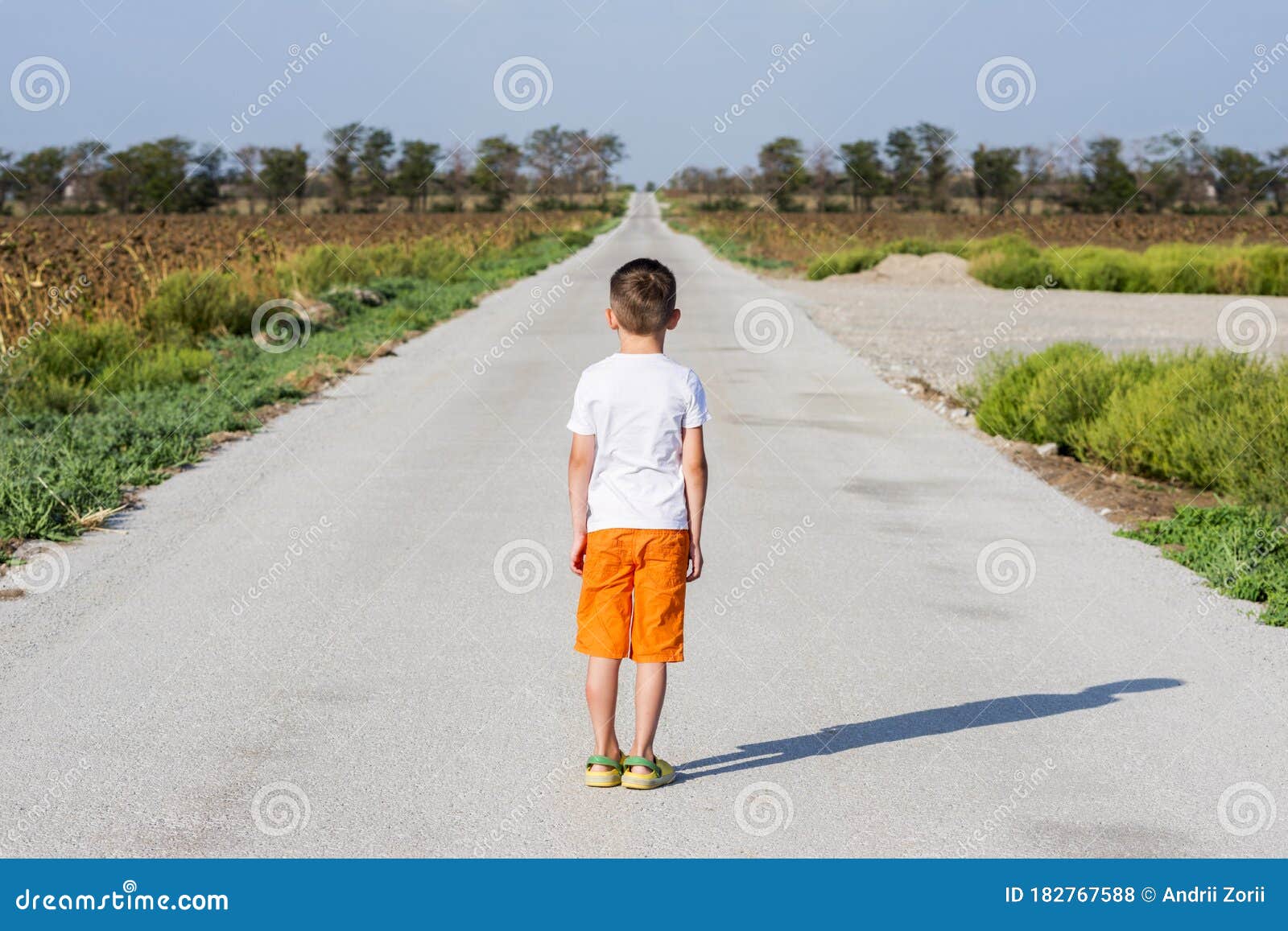 Single Kid Walking Single on Asphalt Road. Little Boy Walking on the