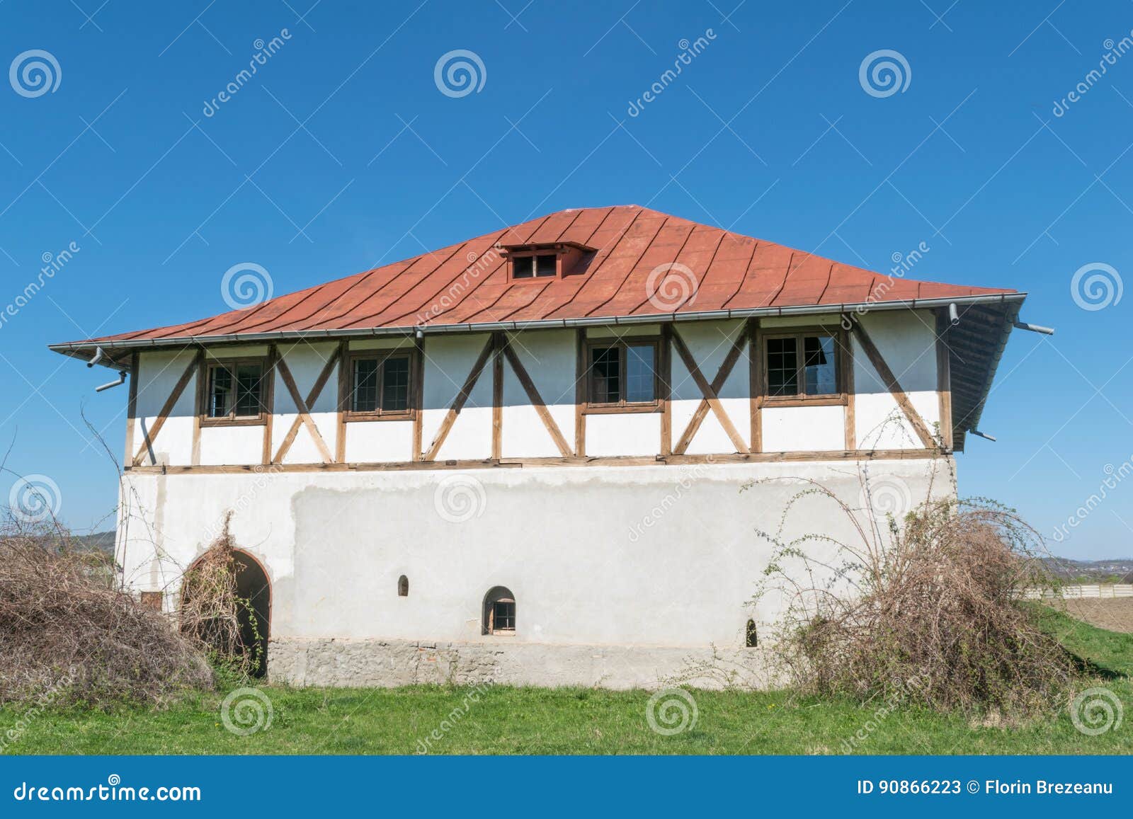 single plain house with intersting wood beans walls and hills in the background