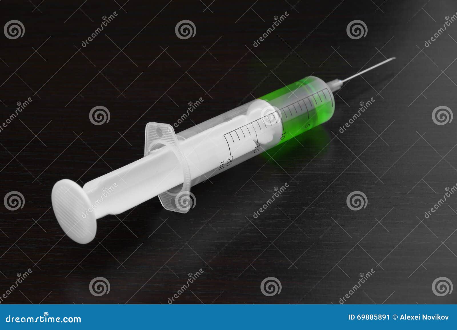 Single Syringe With Green Liquid On The Black Wood Background Stock