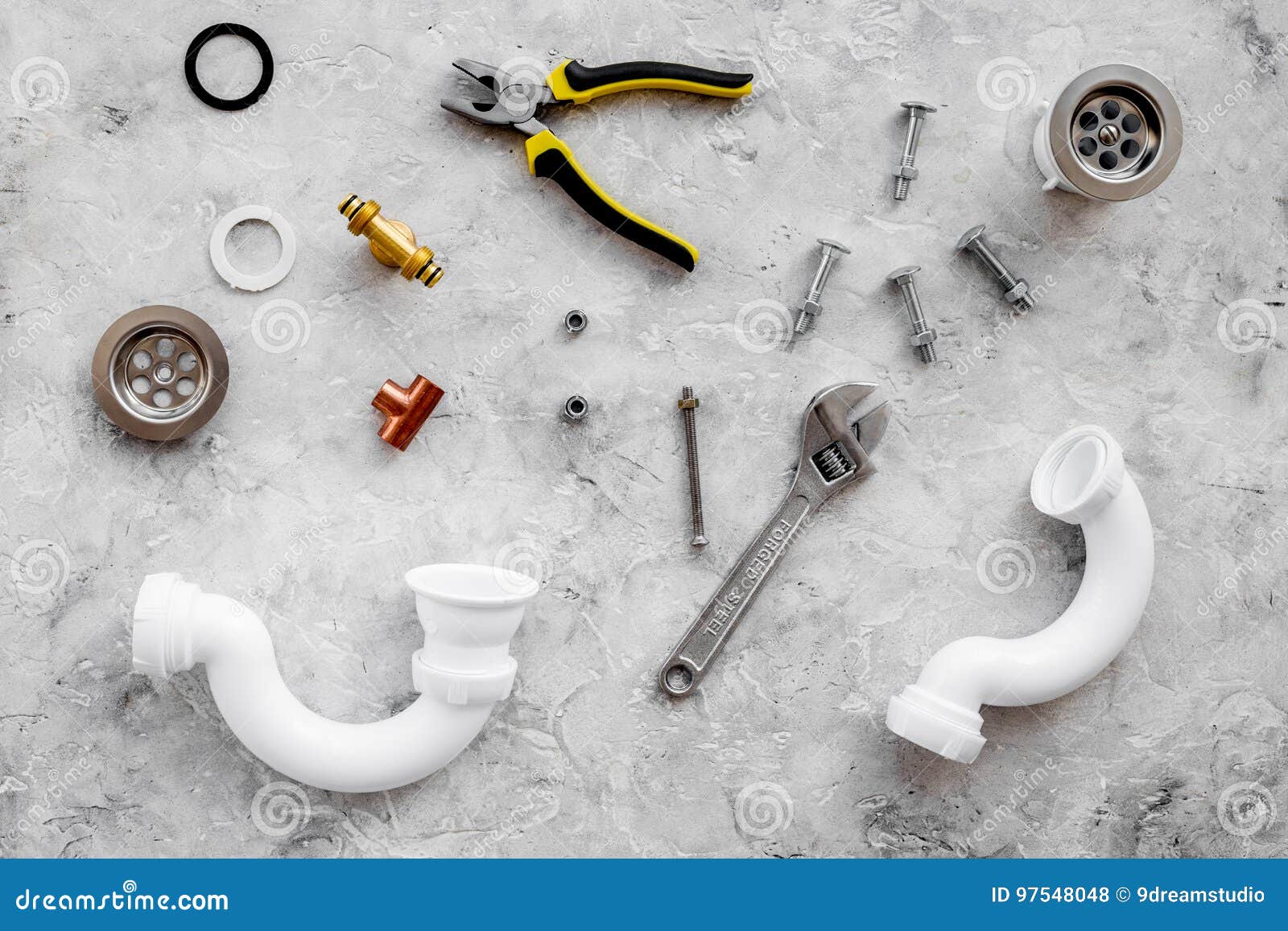 Sink Drain Parts and Plumbing Tools on Grey Stone Background Top View