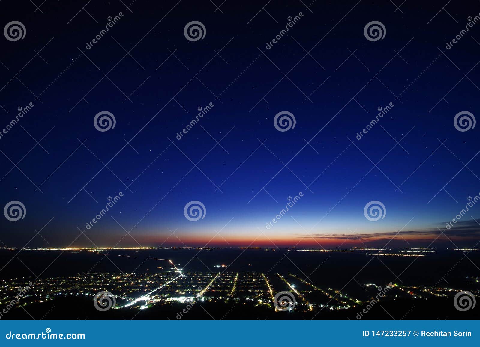 siria village seen from the siria fortress at night. the bright lights of the city arad in the background.