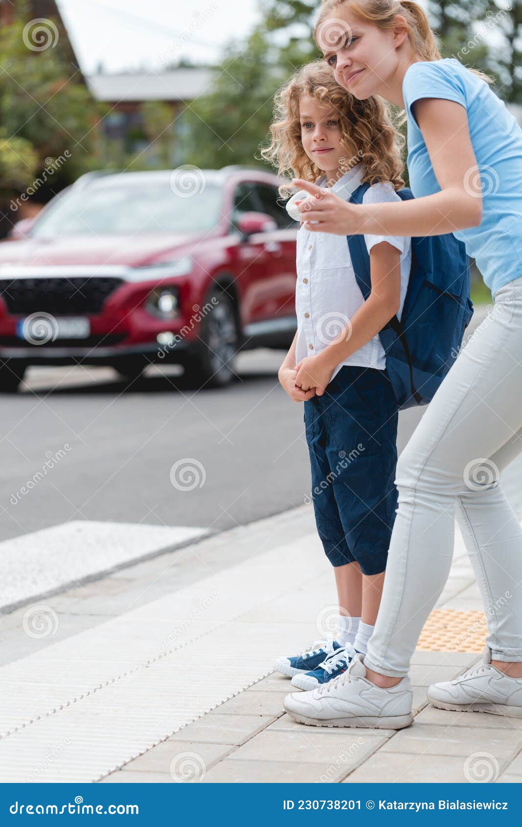 sister explains to the boy how to cross the street safely