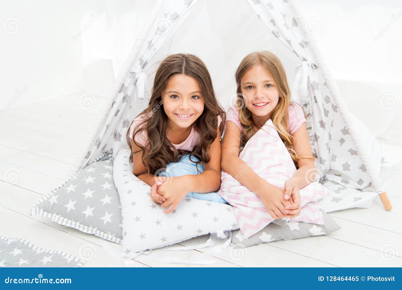 sisters or best friends spend time together lay in tipi house. girls having fun tipi house. girlish leisure. sisters