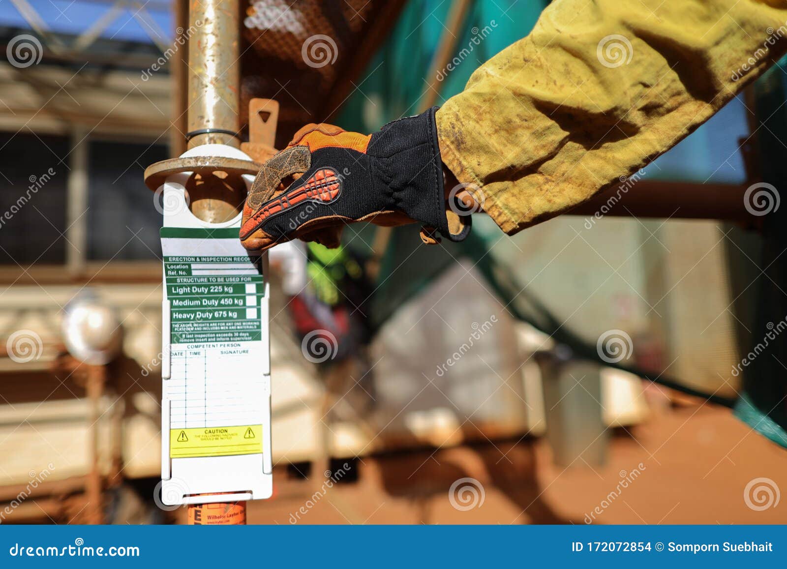 site scaffolder supervisor hand wearing safety cs5 glove protection inspecting scaffolding tag label on standing tube