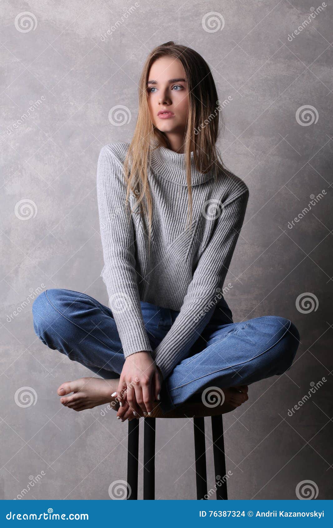 Sitting Girl In Sweater With Crossed Legs Gray Background Sitting Girl In Sweater With Crossed Legs Gray Background