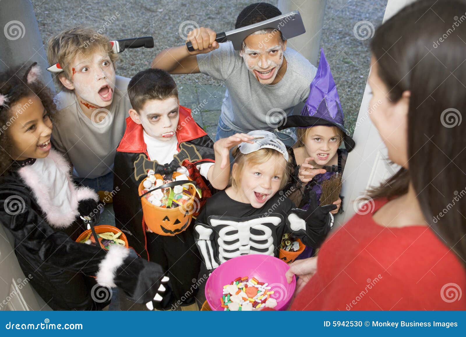 six children in costumes trick or treat at house