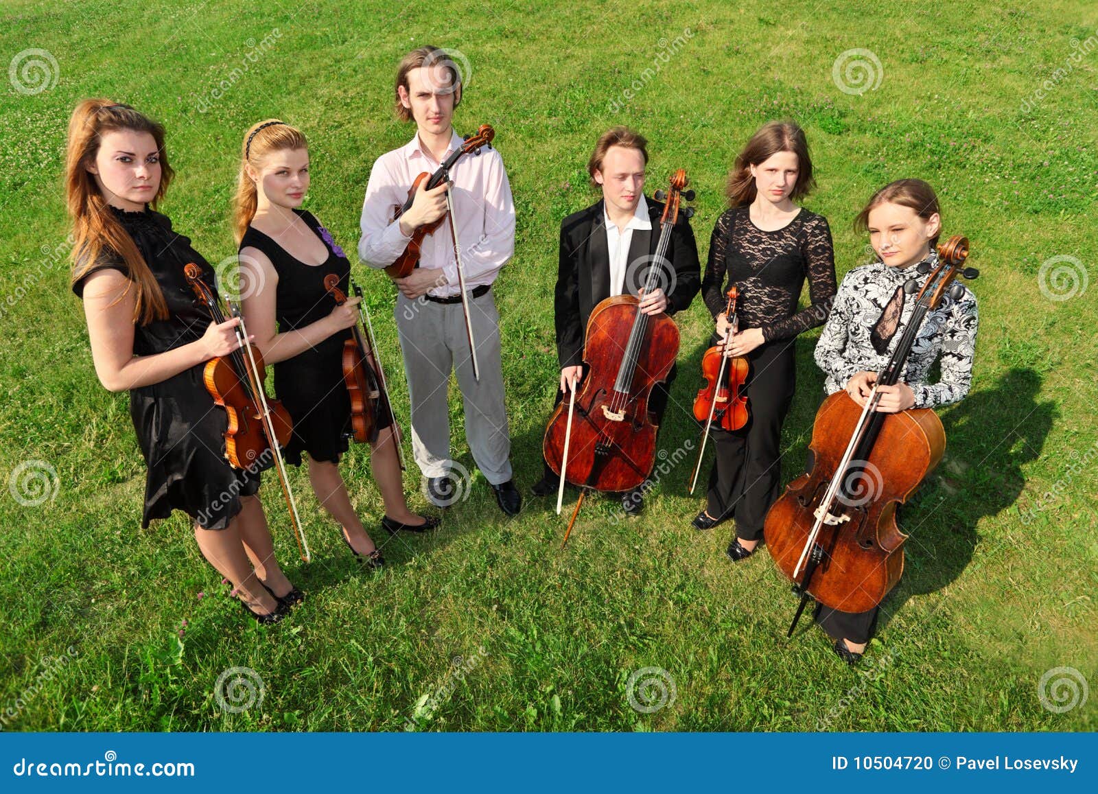 six violinists stand semicircle on grass