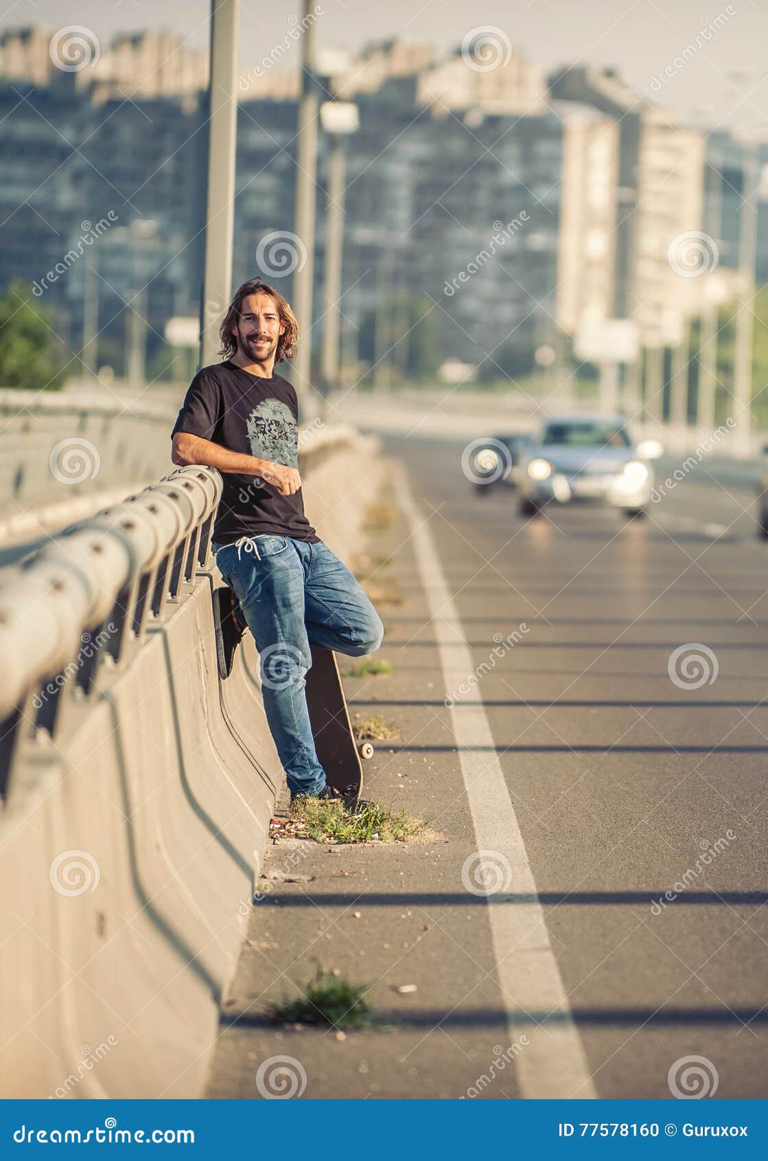 Skateboarder Standing on the Bridge Leaning on a Fence and Watch Stock ...
