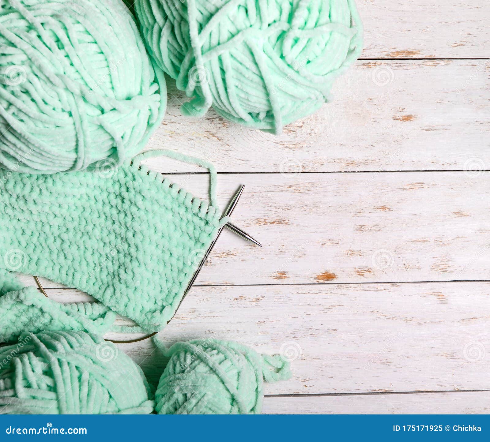Skeins of Wool and Knitting Needles on a Wooden Background Stock Image