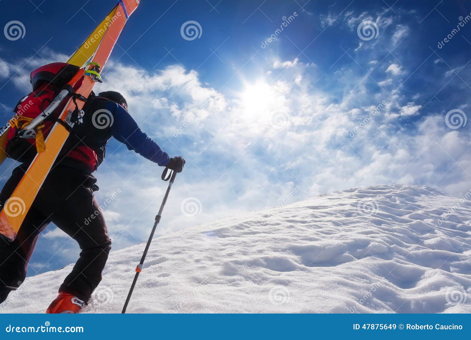 ski mountaineer walking up along a steep snowy ridge with the s