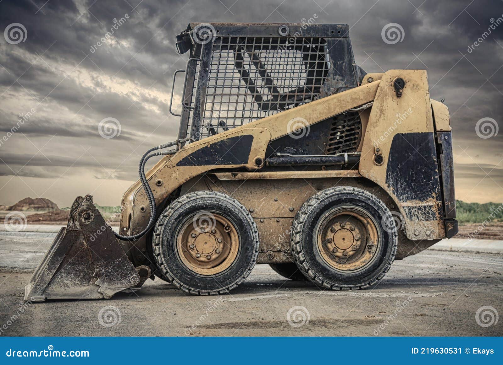 skid steer loader with dark clouds in the background