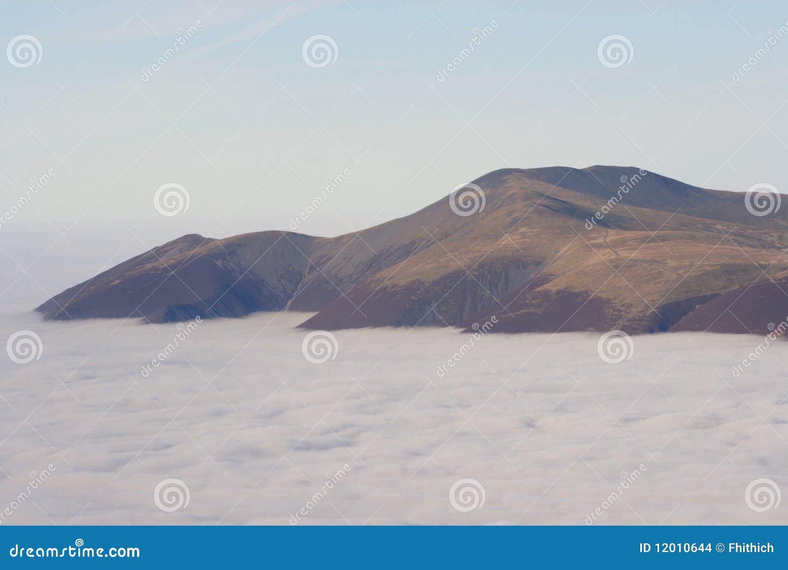 Skiddaw abbatte da Helvellyn. Il livello sulla Regione dei laghi supera lo sguardo attraverso un'inversione di temperatura che ricopre le vallate e le valli qui sotto. Skiddaw aumenta dal mare della nube.