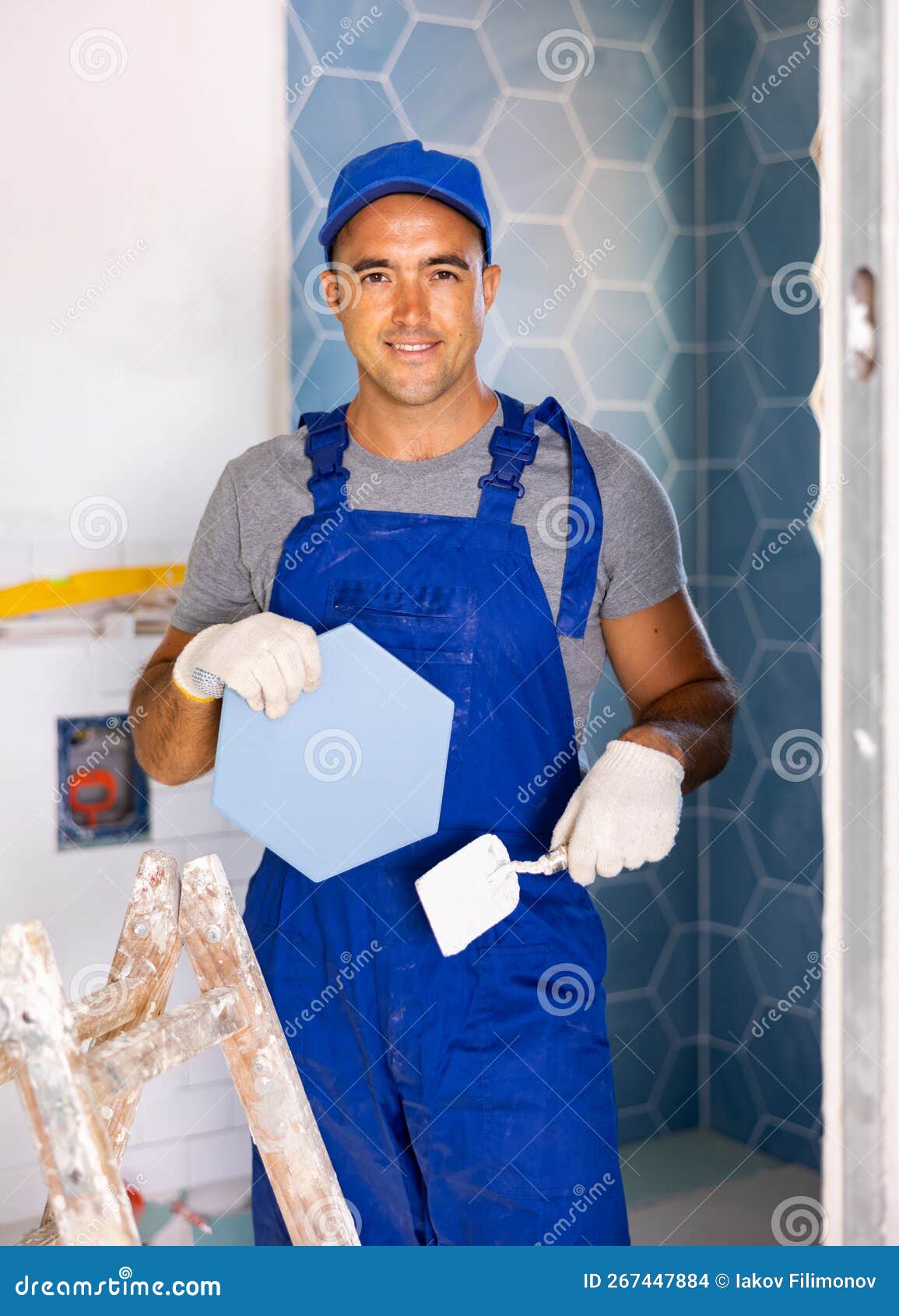 Skilled Builder in Work Clothes Posing with Ceramic Tiles and